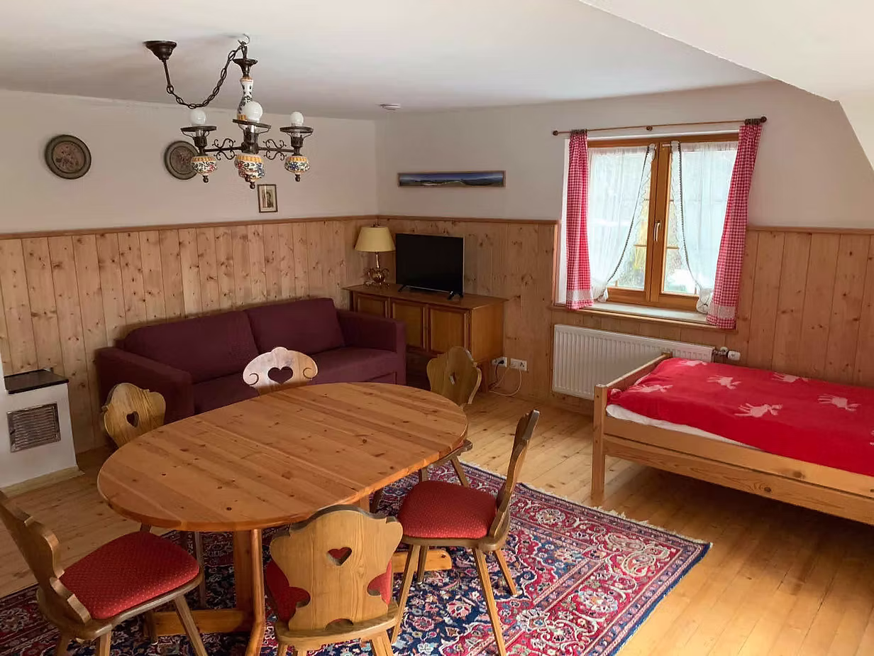 Wohnraum der Ferienwohnung mit Sofa, Esstisch und Bett